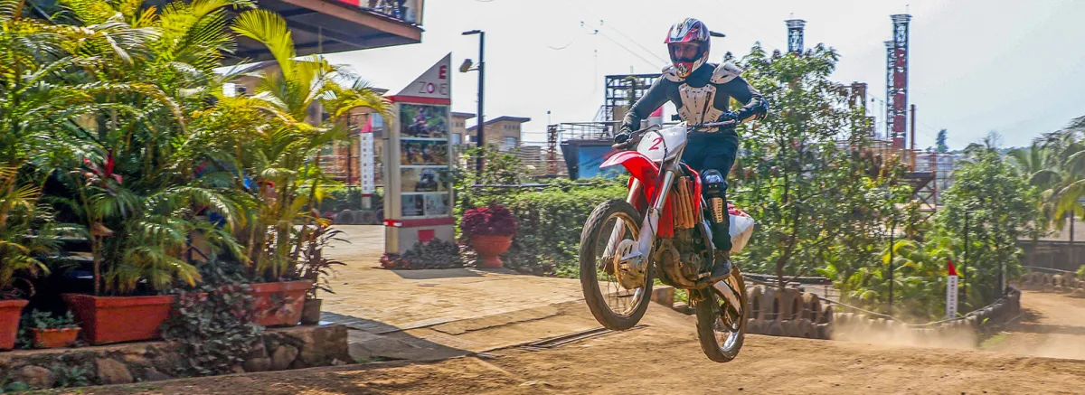 A rider jumping a motocross bike on the dirt track at Della Adventure, Lonavala